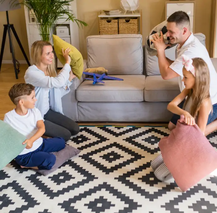 Happy family enjoying time on freshly cleaned patterned rug in living room